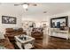 Spacious living room with wood-look flooring, a ceiling fan, and an open layout connecting to the kitchen at 7639 Broad Pointe Dr, Zephyrhills, FL 33540