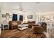 Cozy living room featuring wood-look floors, comfortable sofas, and ample natural light, perfect for relaxation at 7639 Broad Pointe Dr, Zephyrhills, FL 33540