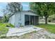 Exterior view of a screened-in porch with paver patio and well maintained yard at 7702 New York Dr, Tampa, FL 33619