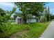 Home exterior with green lawn and trees showcases a cozy, peaceful setting at 7702 New York Dr, Tampa, FL 33619