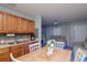Functional kitchen with wooden cabinets, modern appliances, and dining area leading to the living room at 7702 New York Dr, Tampa, FL 33619