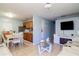 Cozy living room and dining area with tile floors and a wall-mounted television create a comfortable atmosphere at 7702 New York Dr, Tampa, FL 33619