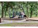 playground with slides and climbing structures in a shady, tree-filled park at 7702 New York Dr, Tampa, FL 33619