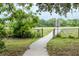 Well-maintained park walking path leads to a peaceful, grassy field with trees at 7702 New York Dr, Tampa, FL 33619
