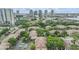 Aerial view of a residential community with lush greenery, rooftops, parking lots, and the city skyline in the background at 820 Normandy Trace Rd, Tampa, FL 33602