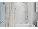 Shower-tub combo features a white tile and modern shower head in bright bathroom at 820 Normandy Trace Rd, Tampa, FL 33602