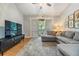 Cozy living room with gray sectional sofa, area rug, TV, shuttered glass doors, and ceiling fan at 820 Normandy Trace Rd, Tampa, FL 33602