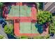 Aerial view of two new tennis courts surrounded by green hedges and trees at 820 Normandy Trace Rd, Tampa, FL 33602