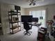 View of a living room with a ceiling fan, large windows, a desk, computers, and shelving at 9100 Mlk N St # 503, St Petersburg, FL 33702