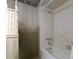 Bathroom features a combination shower and tub with light patterned wallpaper at 9918 Davis Rd, Tampa, FL 33637