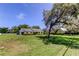 Spacious front yard featuring a charming ranch home with lush greenery and mature trees at 9918 Davis Rd, Tampa, FL 33637
