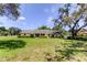 Charming ranch-style home with a well-manicured lawn and lush greenery on a sunny day at 9918 Davis Rd, Tampa, FL 33637