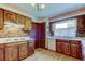 Charming kitchen featuring wood cabinets, brick accents, and an eat-in breakfast bar at 9918 Davis Rd, Tampa, FL 33637