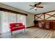 Bright living room with hardwood floors, large windows, and cozy red sofa at 9918 Davis Rd, Tampa, FL 33637