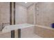 Elegant soaking tub surrounded by beige tiling and a decorative mosaic tile border at 1 Beach Se Dr # 2011, St Petersburg, FL 33701