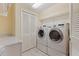 Well-equipped laundry room with a side-by-side washer and dryer, storage cabinets, and folding counter at 1 Beach Se Dr # 2011, St Petersburg, FL 33701
