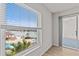 Bright bedroom with a large window overlooks a pool, boat dock, and waterway at 105 Island Way # 126, Clearwater Beach, FL 33767