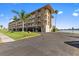 Waterfront condo building featuring multiple floors, private balconies, palm trees, and dedicated parking at 105 Island Way # 126, Clearwater Beach, FL 33767