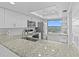 Modern kitchen showcasing white cabinets, stainless appliances, and a granite countertop with a sink at 105 Island Way # 126, Clearwater Beach, FL 33767