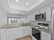 Modern kitchen with stainless appliances, granite counters, and seamless flow to living space at 105 Island Way # 126, Clearwater Beach, FL 33767