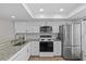Kitchen featuring white cabinets, stainless steel appliances, and stone countertops at 105 Island Way # 126, Clearwater Beach, FL 33767