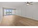 Spacious living room featuring wood floors and a large sliding glass door to the balcony at 105 Island Way # 126, Clearwater Beach, FL 33767