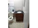 Compact bathroom with a dark vanity countertop, framed mirror, and ceramic tile flooring at 11541 Orleans Ln, Port Richey, FL 34668