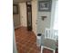 Hallway with a tall case clock, front door, picture, and a white chair at 11541 Orleans Ln, Port Richey, FL 34668