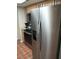 Stainless steel refrigerator in kitchen with brown tile floors, oven, and microwave at 11541 Orleans Ln, Port Richey, FL 34668