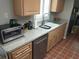Kitchen featuring light wood cabinets, stainless steel appliances, and tile floor at 11541 Orleans Ln, Port Richey, FL 34668