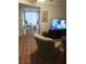 Living room featuring tile floors, shutters, television, and an upholstered chair at 11541 Orleans Ln, Port Richey, FL 34668