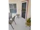 Outdoor patio with chairs, small table, and view of the natural surroundings and a storm door at 11541 Orleans Ln, Port Richey, FL 34668
