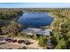 Stunning aerial view of a lakeside property with lush greenery and modern architecture near a walking trail at 11551 Callisia Dr, Odessa, FL 33556