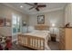 Cozy bedroom with natural light, ceiling fan, wood floors, and comfortable furnishings at 11551 Callisia Dr, Odessa, FL 33556
