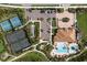 Aerial shot of resort-style amenities: tennis courts, pool, parking, and lush landscaping at 11551 Callisia Dr, Odessa, FL 33556