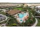 Aerial view of a luxurious community pool with palm trees, cabanas, and ample seating at 11551 Callisia Dr, Odessa, FL 33556