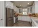 A modern kitchen features white cabinets, stainless steel appliances, and plenty of counter space at 11551 Callisia Dr, Odessa, FL 33556