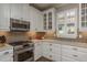 Modern kitchen featuring stainless steel appliances, white cabinetry, and granite countertops, perfect for culinary enthusiasts at 11551 Callisia Dr, Odessa, FL 33556
