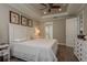 Comfortable main bedroom featuring wood floors, a tray ceiling with fan, and a glimpse into the ensuite bathroom at 11551 Callisia Dr, Odessa, FL 33556