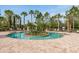 Inviting community pool with island feature, surrounded by lush landscaping and lounge chairs for relaxing by the water at 11551 Callisia Dr, Odessa, FL 33556