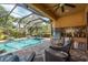 Outdoor screened-in pool area with grill and ample seating for relaxation and entertaining at 11551 Callisia Dr, Odessa, FL 33556
