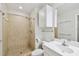 Cozy bathroom with walk-in shower, neutral tiling, white vanity, and mirrored cabinet at 119 Beach Haven Ln, Tampa, FL 33609