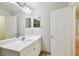 White bathroom with a large mirror, spacious vanity, and neutral tile flooring at 119 Beach Haven Ln, Tampa, FL 33609