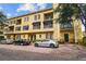Three-story condo building with brick-paved parking area and multiple cars parked out front on a sunny day at 119 Beach Haven Ln, Tampa, FL 33609