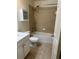 A bathroom with a bathtub, tiled walls, and white vanity at 125 Grand Beach Pl # 125, Tampa, FL 33609