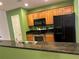 A kitchen with wood cabinets, black appliances, and dark countertops at 125 Grand Beach Pl # 125, Tampa, FL 33609