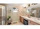 Bathroom with double vanity, large mirror, and a glass-enclosed shower at 15348 Glossy Ibis Rd, Weeki Wachee, FL 34614