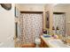 Cozy bathroom featuring a shower/tub combo with seashell shower curtain, and a wooden vanity at 15348 Glossy Ibis Rd, Weeki Wachee, FL 34614