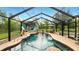 Inviting screened-in pool with waterfall feature and poolside seating area at 15348 Glossy Ibis Rd, Weeki Wachee, FL 34614