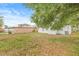 The backyard includes a grassy area, partially fenced, with mature trees at 1713 W Saint John St, Tampa, FL 33607